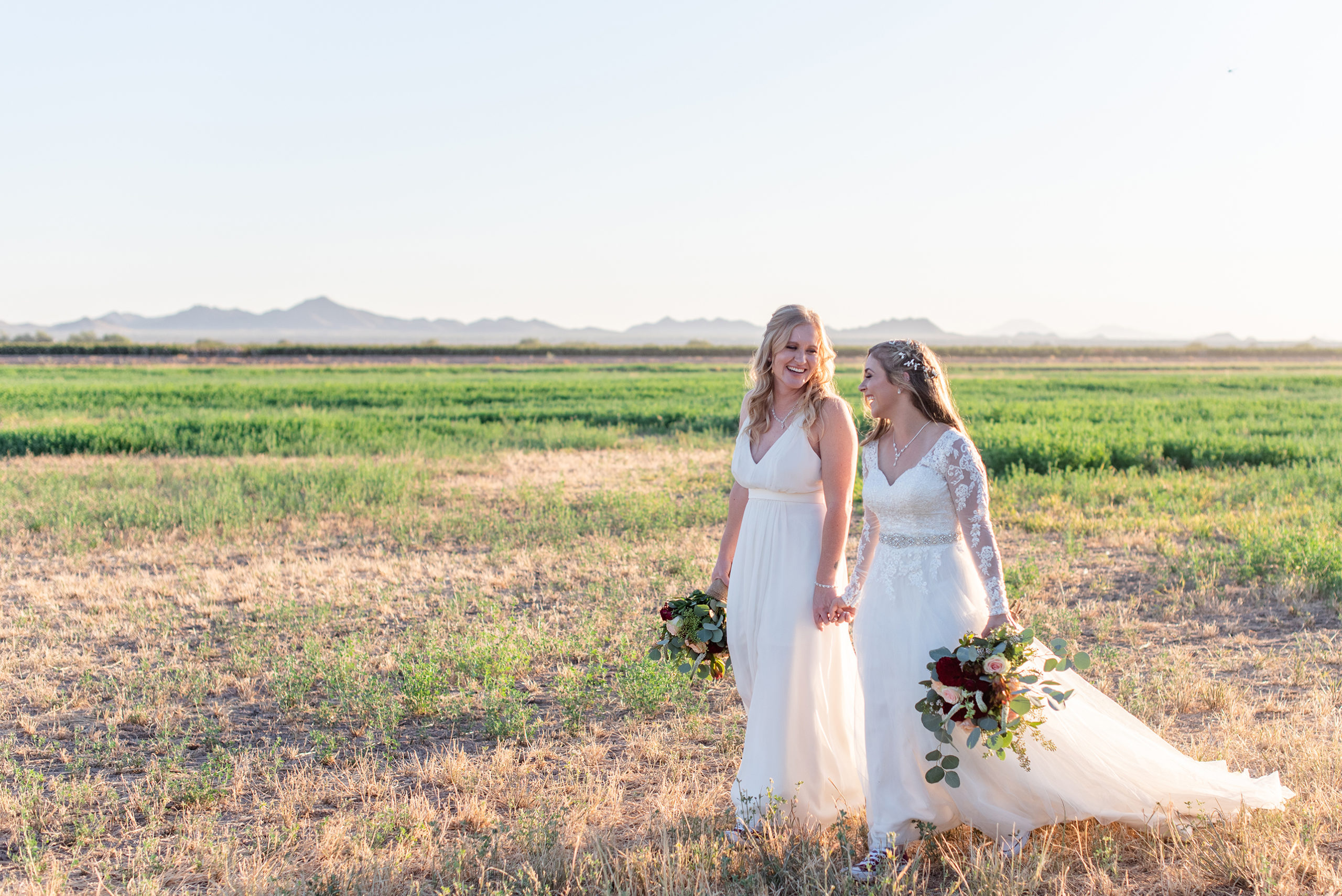 lgbtq brides holding hands at wellington ranch field